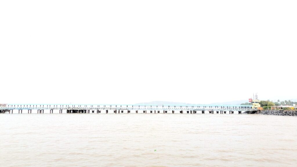 Long waterfront jetty extending over calm coastal waters by isprava.
