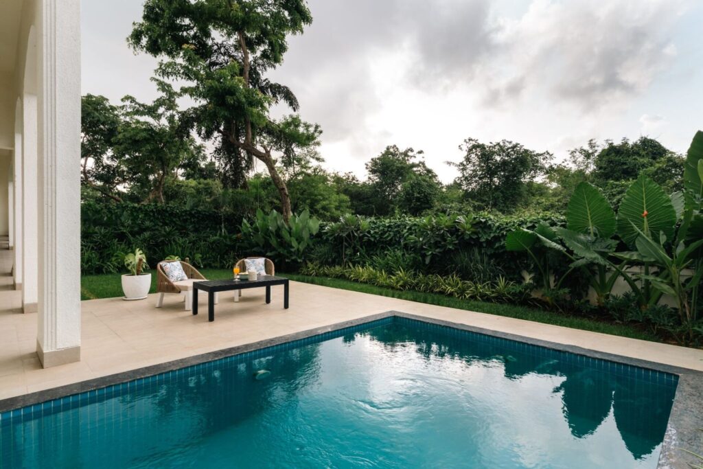 Luxury villa with private swimming pool, landscaped garden, and outdoor seating area by Isprava.