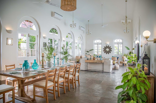 Spacious luxury villa dining and living area with elegant interiors and large arched windows by Isprava.